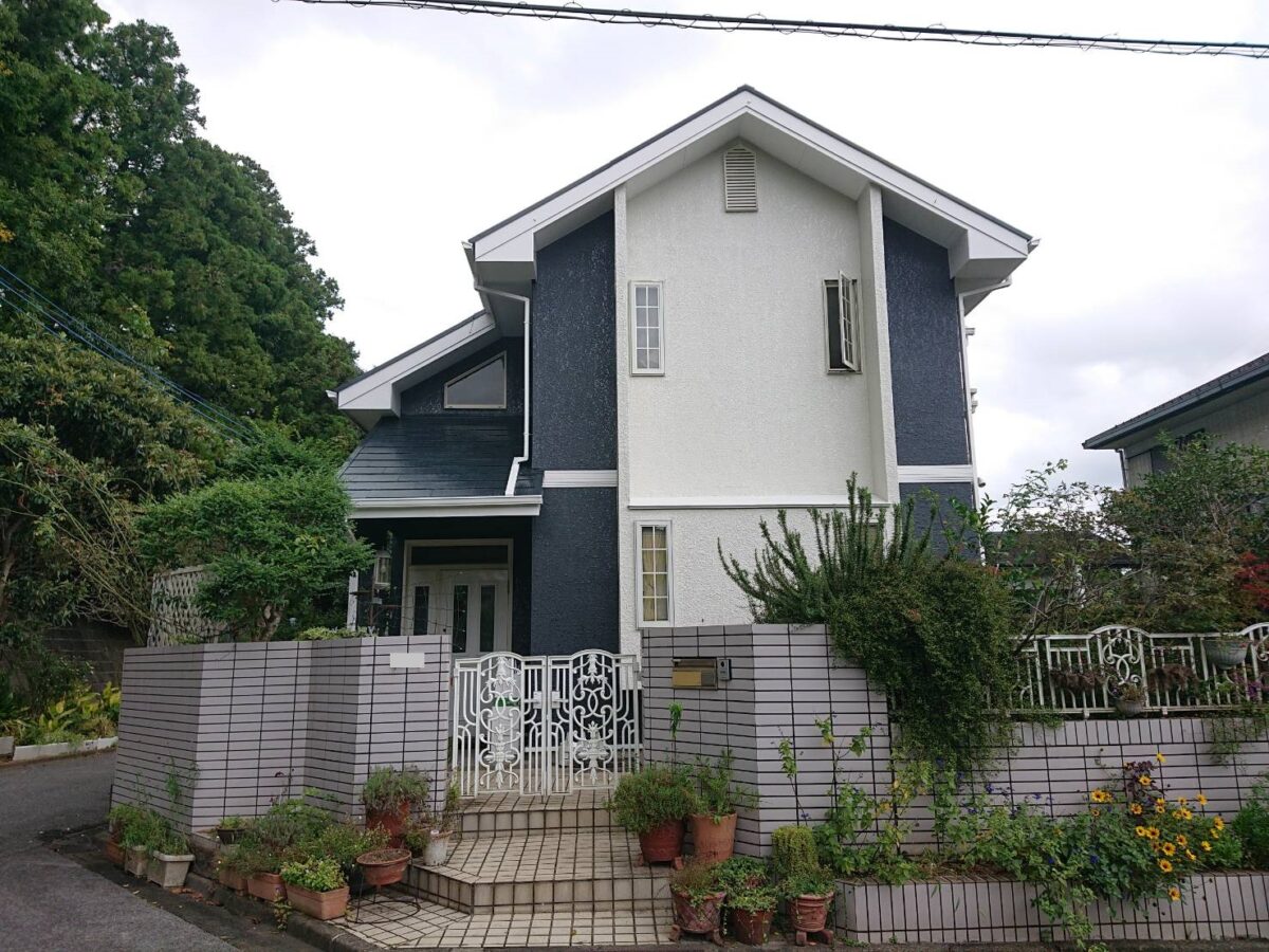 空と緑に調和するバイカラーの外観